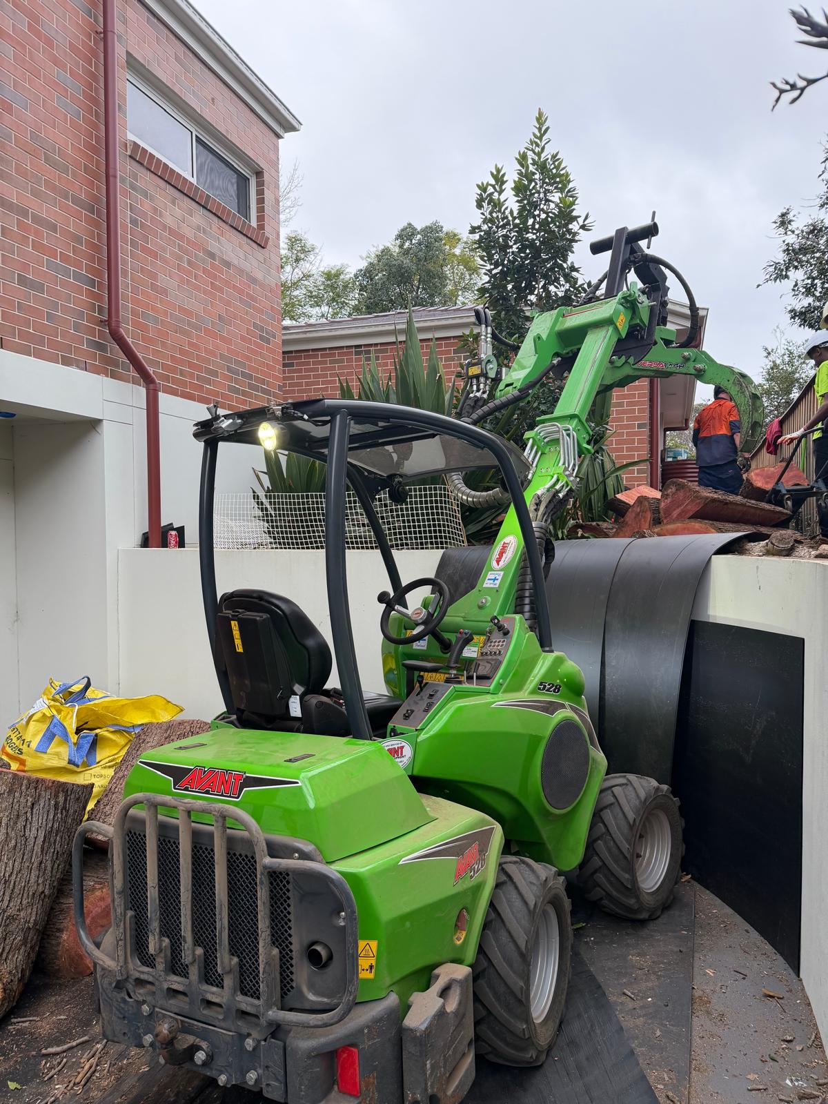 True Roots crew and machine moving cut logs off a tree removal job in Strathfield