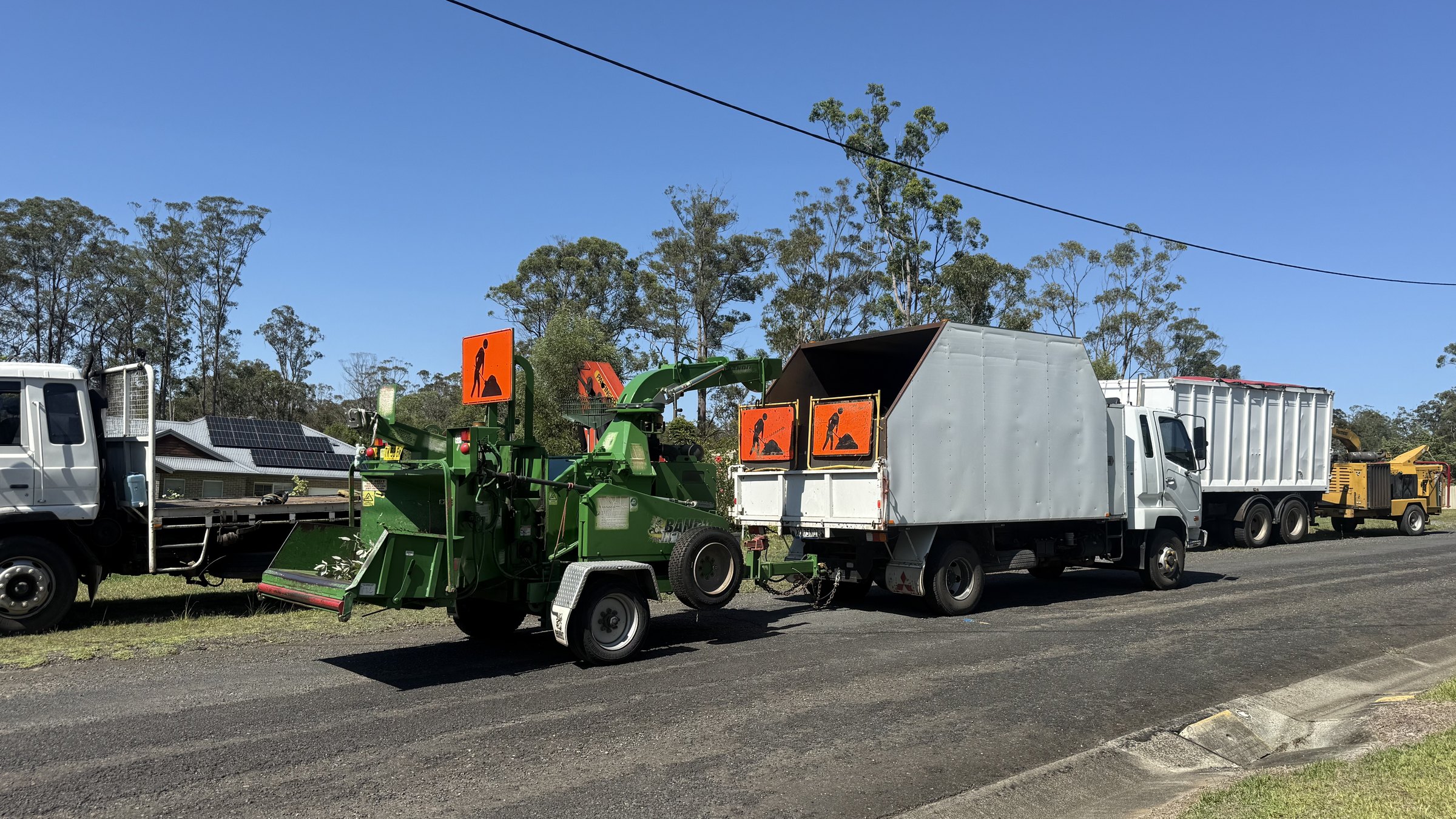 True Roots chipper trucks and crew processing branches at the roadside, Sydney