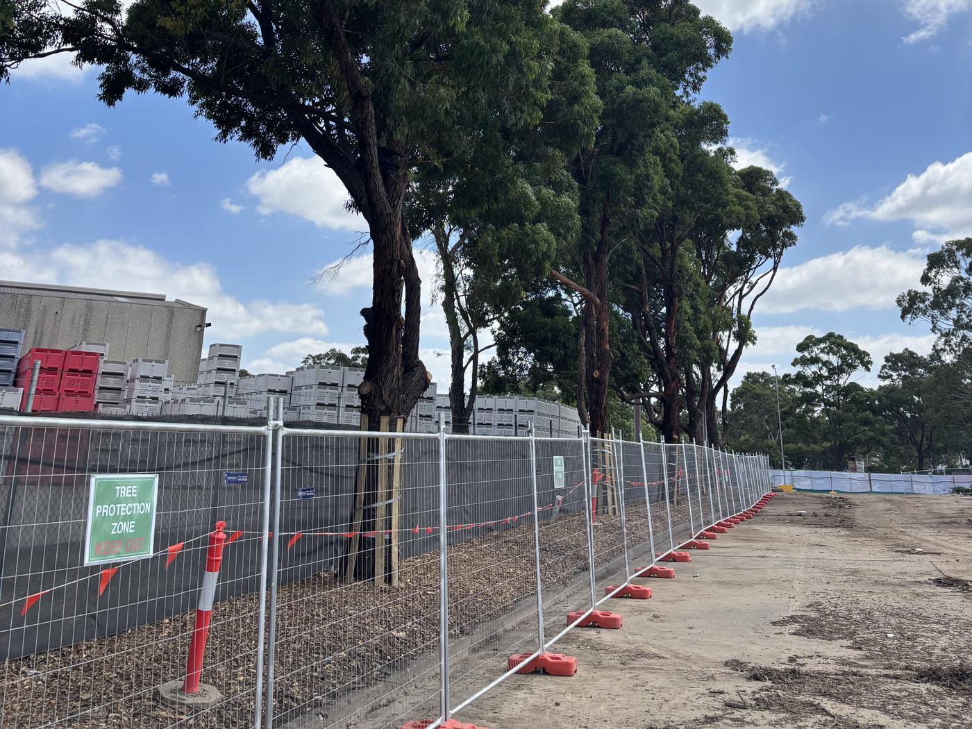 Tree protection zone fencing and sign around retained trees on a commercial building site